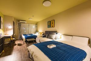 een hotelkamer met twee bedden en een bureau bij Sky Living Namba in Osaka