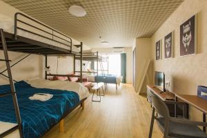 een slaapzaal met een stapelbed en een bureau bij Sky Living Namba in Osaka
