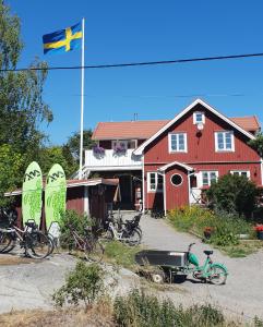 a flag flying in front of a red house with bikes at STF Möja Vandrarhem in Möja