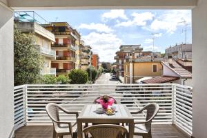 a table on a balcony with a view of a street at Hotel La Pineta in Follonica