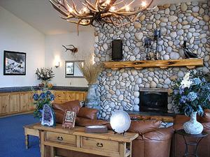 a living room with a couch and a stone wall at Edgewater Inn Shady Cove in Shady Cove