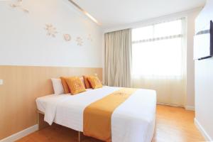a bedroom with a large bed with a window at China Town Hotel - SHA Plus Certified in Bangkok