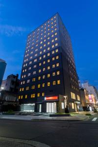 a tall black building with many windows on a street at Via Inn Nagoya Station Tsubaki-cho in Nagoya