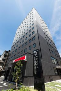 Un palazzo alto con un cartello davanti di Via Inn Nagoya Station Tsubaki-cho a Nagoya