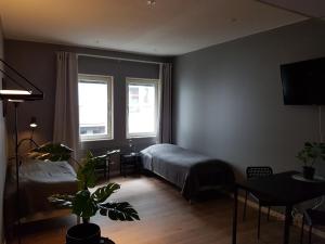 1 dormitorio con cama, mesa y ventana en Apartments Uppsala - Portalgatan en Uppsala