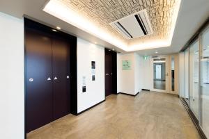 a hallway with black doors and a ceiling at Via Inn Nagoya Station Tsubaki-cho in Nagoya