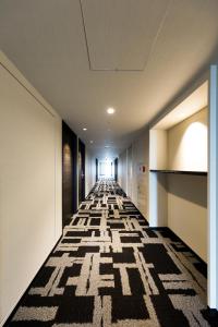 a long hallway with a patterned floor in a building at Via Inn Nagoya Station Tsubaki-cho in Nagoya