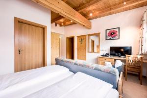 莱奥冈Naturresort PURADIES的一间卧室，配有一张床、一张书桌和一台电视