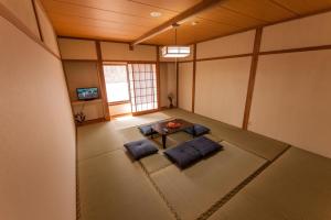 a room with a table and chairs in a room at 金剛寺 宿坊 成穂院 in Matsukawa