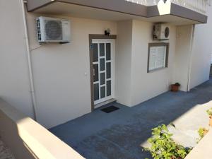 a white building with a door and a air conditioner at Mamis Studio in Kissamos