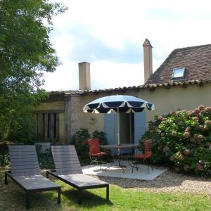 un patio con mesa, sillas y sombrilla en Domaine De La Mouthe, en Saint-Rémy