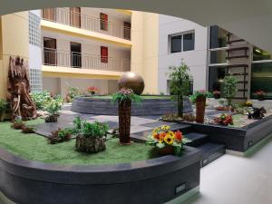 a courtyard of a building with flowers and plants at Golden Pearl Hotel in Bangkok