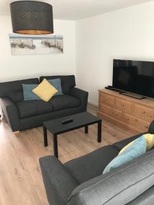 a living room with a couch and a flat screen tv at Eastbourne, Sovereign Harbour Holiday Home in Eastbourne