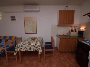 a kitchen with a table and chairs and a kitchen with a stove at Kobale 1 in Veli Lošinj