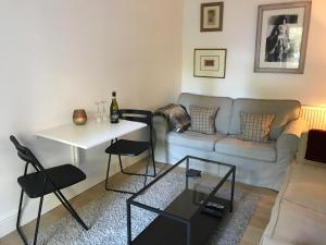 a living room with a couch and a table at Snug at Combe Hay in Bath +15 photos