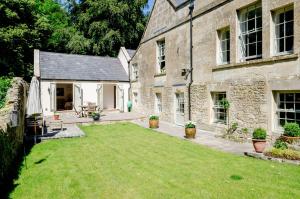 a large yard in front of a stone house at Snug at Combe Hay in Bath