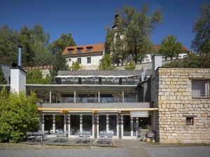 ein Gebäude mit Tischen und Stühlen davor in der Unterkunft Hotel La Romantica in Mladá Boleslav