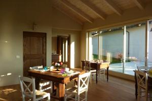 een eetkamer met tafels en stoelen en een groot raam bij La Mela Antica in Cherasco