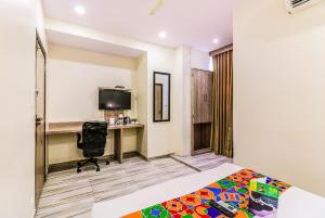 a bedroom with a bed and a desk with a computer at FabHotel Aksa International Andheri East in Mumbai