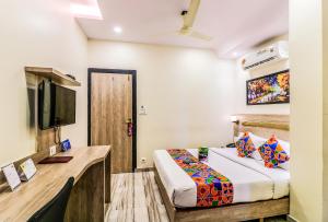 a hotel room with a bed and a tv at FabHotel Aksa International Andheri East in Mumbai