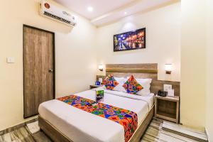 a hotel room with a bed and a television at FabHotel Aksa International Andheri East in Mumbai