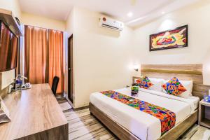 a hotel room with a bed and a desk at FabHotel Aksa International Andheri East in Mumbai