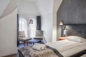 a bedroom with a large bed and two chairs at K7 Hotel Oslo in Oslo