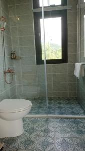 łazienka z prysznicem, toaletą i oknem w obiekcie Moshang Caoxun w mieście Changbin