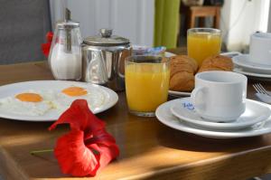 a breakfast table with eggs and coffee and orange juice at Dolphins Apartments in Kamari