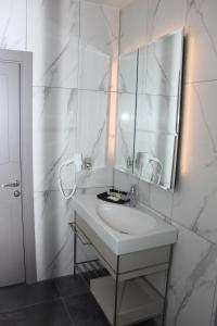 a white bathroom with a sink and a mirror at Anka Premium Hotel in Istanbul