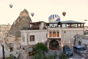 a building with hot air balloons in the sky at Ascension Cave Suites - Special Class in Göreme