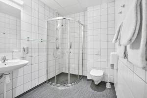 a bathroom with a shower and a toilet and a sink at K7 Hotel Oslo in Oslo