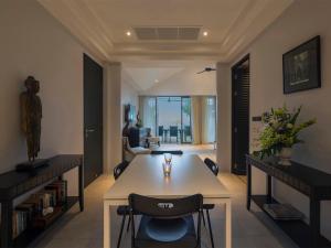 a living room with a table and chairs at Infinity Blue Phuket by Elite Havens in Natai Beach +47 photos