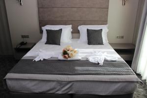 uma cama grande com lençóis brancos e flores em Anka Premium Hotel em Istambul