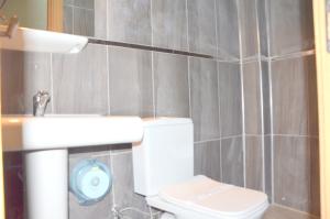 a bathroom with a white toilet and a sink at Elit Hotel Saray in Saray