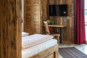 Zimmer mit einem Bett, einem Schreibtisch und einem TV in der Unterkunft Pension und Appartements Wild in Otterfing