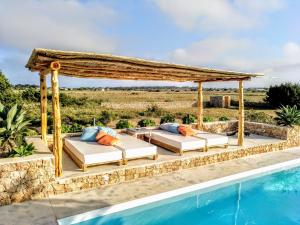 a gazebo next to a swimming pool at cansantidesmonestir in La Mola