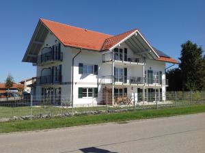 une grande maison blanche avec un toit orange dans l'établissement Pension und Appartements Wild, à Otterfing