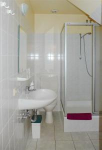 y baño con lavabo, aseo y ducha. en Pension Am Bodden, en Ribnitz-Damgarten