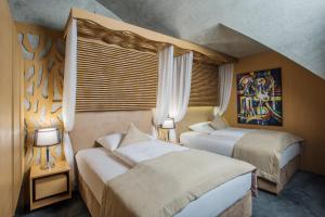 ein Schlafzimmer mit 2 Betten und einem Wandgemälde in der Unterkunft Wellness Hotel Step in Prag