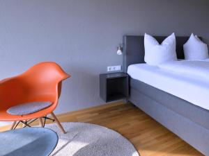 Cette chambre comprend un lit, une chaise et un lit. dans l'établissement Am Paradies, à Müllheim