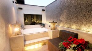 a bathroom with a tub and a bench and flowers at agehA - Adult Only- in Fukuyama