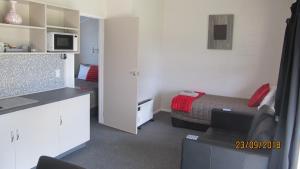 een kleine kamer met een bed en een magnetron bij Ahuriri Motels in Omarama
