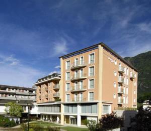 a large apartment building in front of a mountain at Rizzi Aquacharme Hotel & Spa in Boario Terme