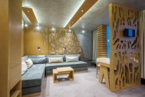 ein Wohnzimmer mit einem Sofa und einer Holzwand in der Unterkunft Wellness Hotel Step in Prag