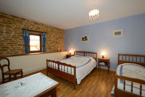1 dormitorio con 2 camas, mesa y sillas en Chambres d'hôtes L'Hirondelle en Girondelle
