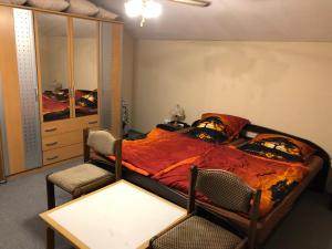 a bedroom with a bed and two chairs and a table at HeRo 4 Sterne Ferienhaus in Baja