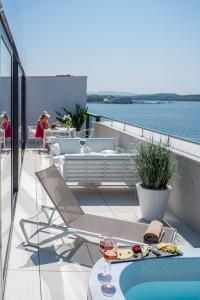 a balcony with a table and chairs on a boat at Bellevue Superior City Hotel in Šibenik