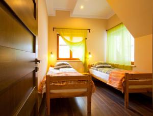 two beds in a small room with a window at Apartamenty Kosciuszki 8 in Zakopane
