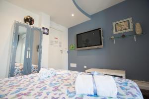 a bedroom with a bed and a tv on the wall at Versomare in Polignano a Mare